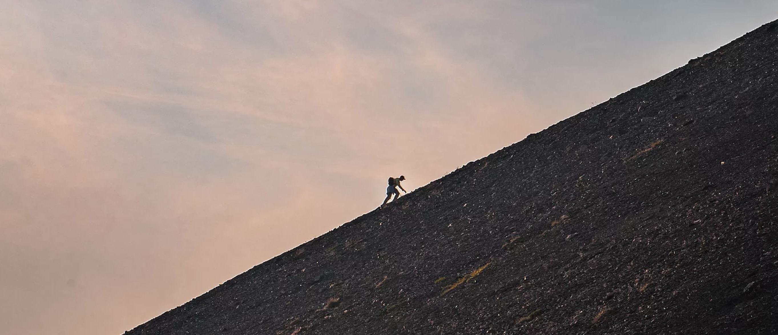 Hiker scaling a rocky mountain in Alaska