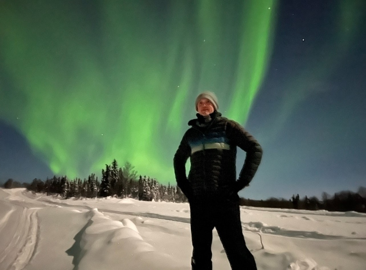 Guide Michael "Shaggy" standing under the northern lights