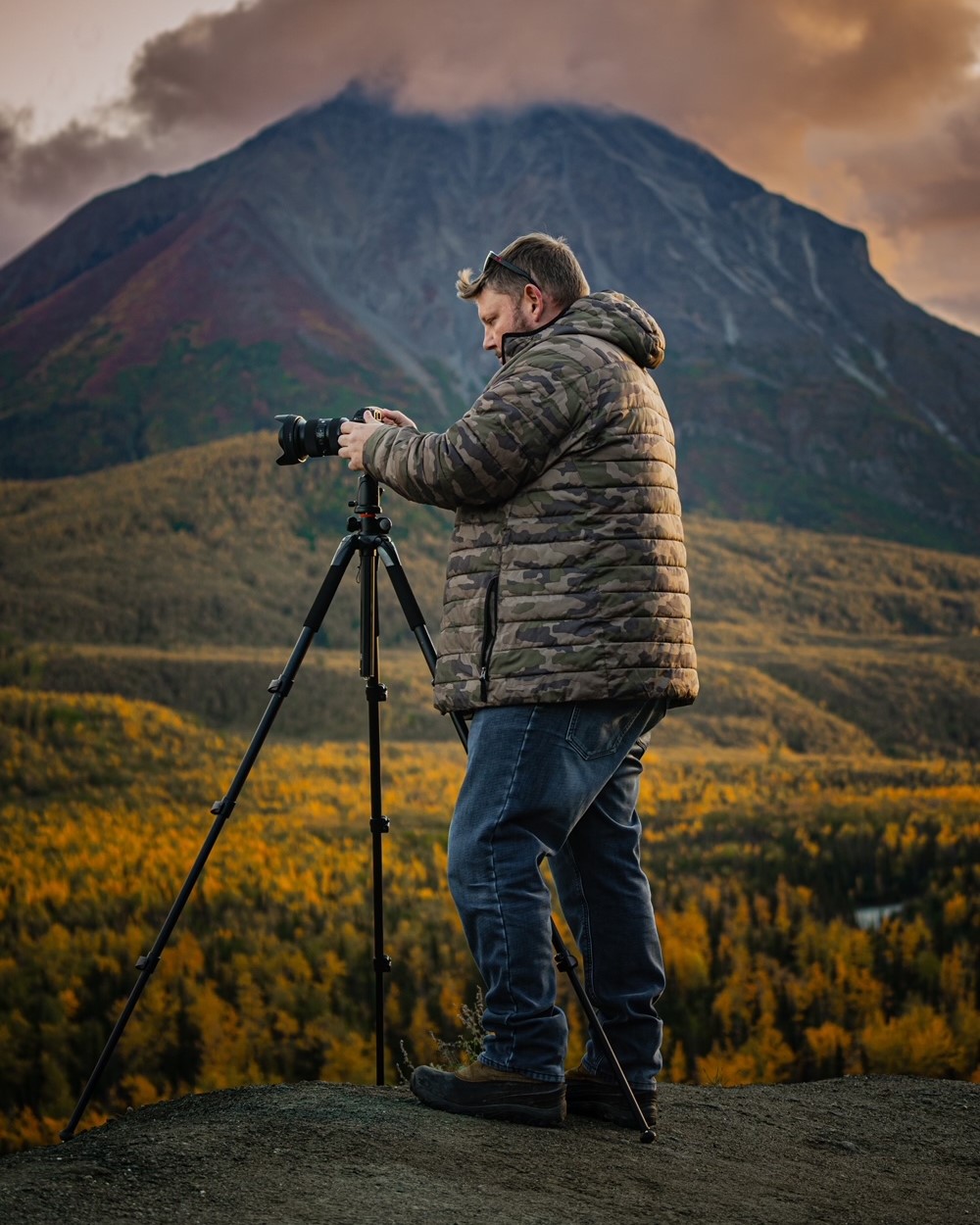 a person setting up a tripod camera in Alaska